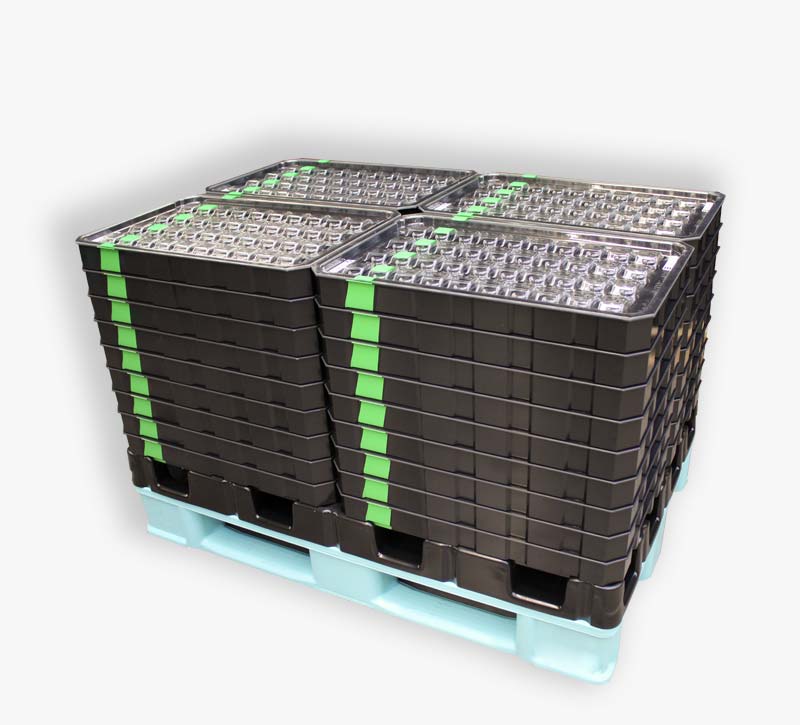 Packaging unit for bearing caps consisting of a pallet, stack bases, workpiece carriers and dust protection lids.